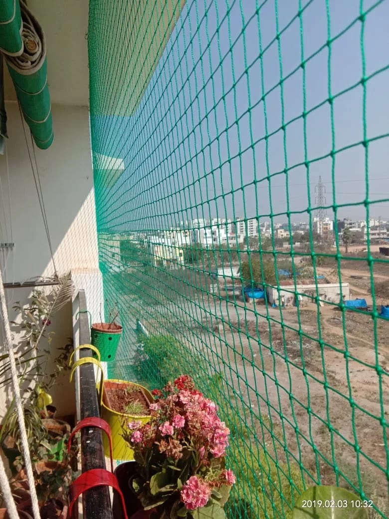 Green balcony safety net installed on apartment balcony