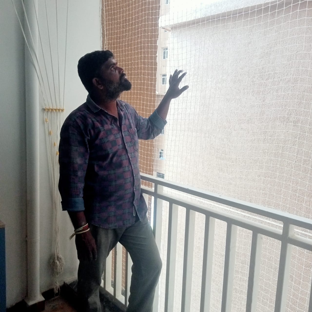 Technician inspecting installed balcony safety net